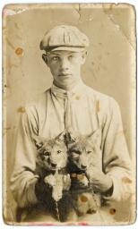 Young man holding two small dogs