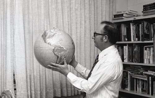 Portrait Ricks College faculty holding a globe