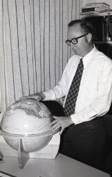 Portrait Ricks College faculty examining a globe